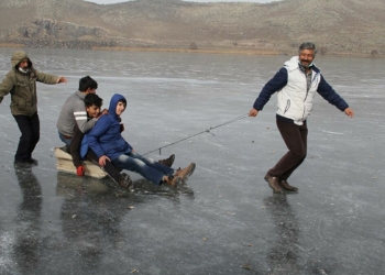 Göl yüzeyinde kızak yaparak buzun tadını çıkarıyorlar