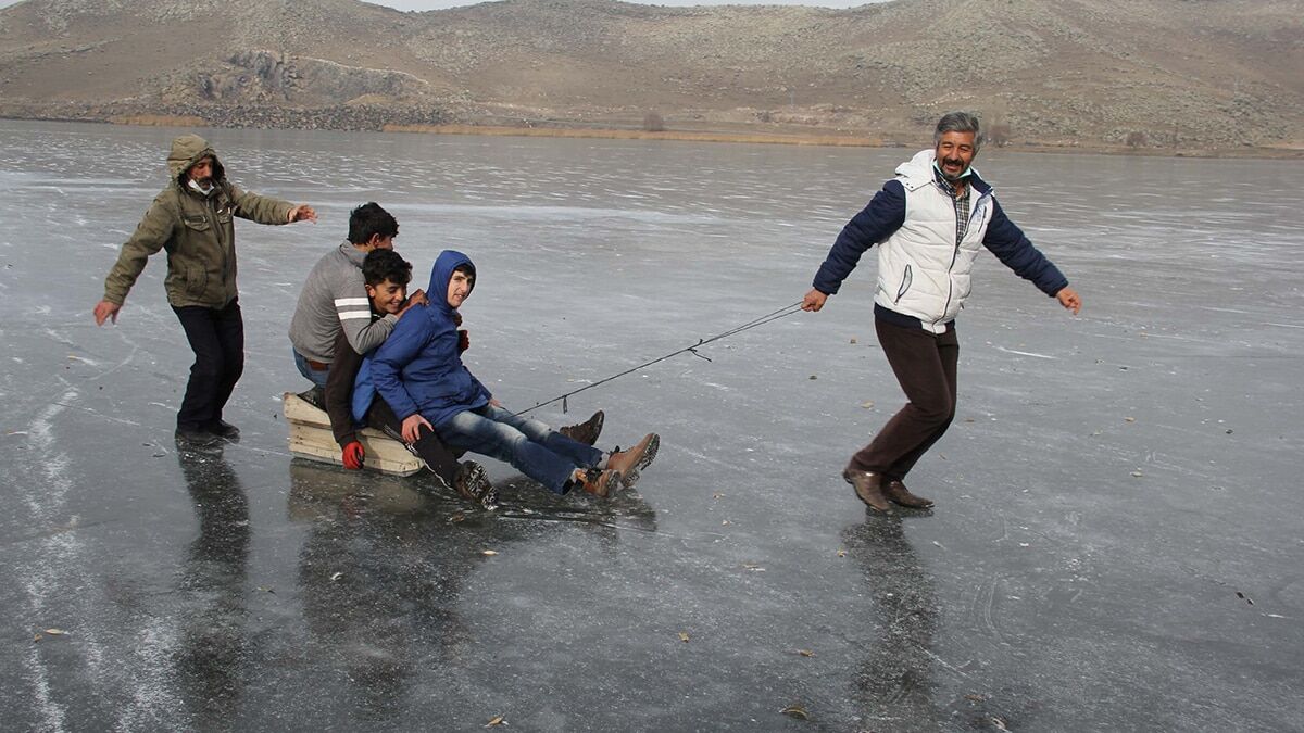 Göl yüzeyinde kızak yaparak buzun tadını çıkarıyorlar