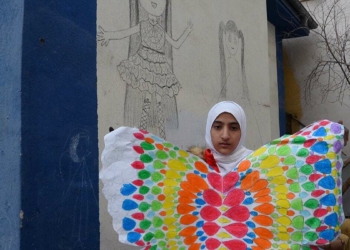 Yerden topladığı kömürle duvara resim çiziyor