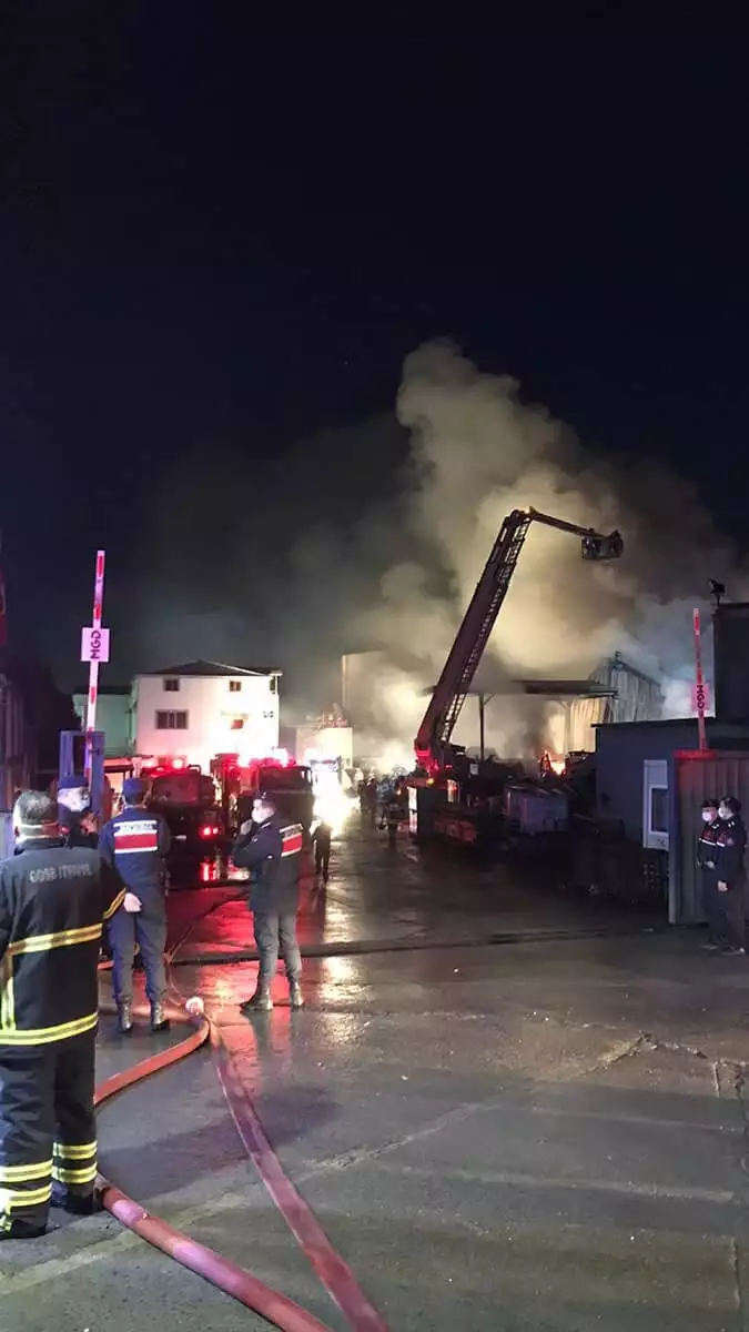 Alevlerin içerisinde kalan geri dönmüşüm malzemeleri fabrika binasının dışına çıkarılıyor.