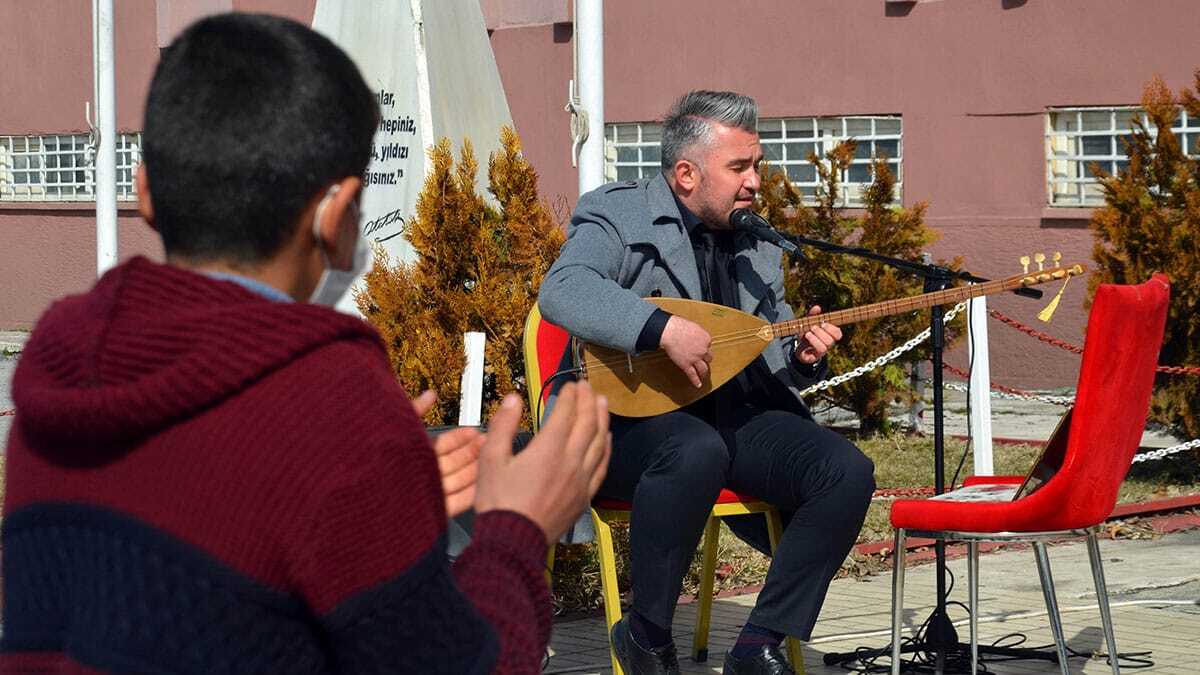 Müzik Öğretmeni Halil Emre İleri ve diğer öğretmenler tarafından müzikle karşılanıyor. Koronavirüs nedeniyle evden çıkarken taktıkları maskeleri okul bahçesine girerken çöpe atan öğrenciler, burada kurulan stantta ellerini dezenfekte ediyor.