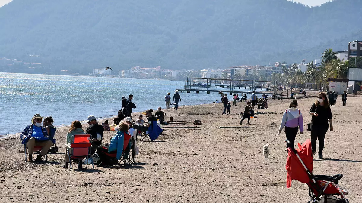Marmaris'te güneşli havayı görenler sabah saatlerinden itibaren sahili doldurdu. Görevliler,  vatandaşlara maske ve sosyal mesafe uyarısı yaptı.