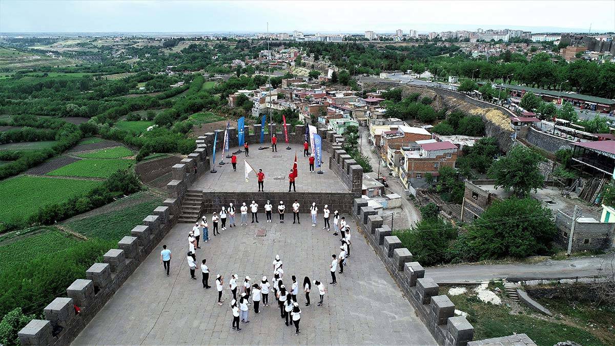 40 genç sporcu 5 bin yıllık tarihi surlarda ay yıldız koreografisi oluşturarak, İstiklal Marşı okudu.