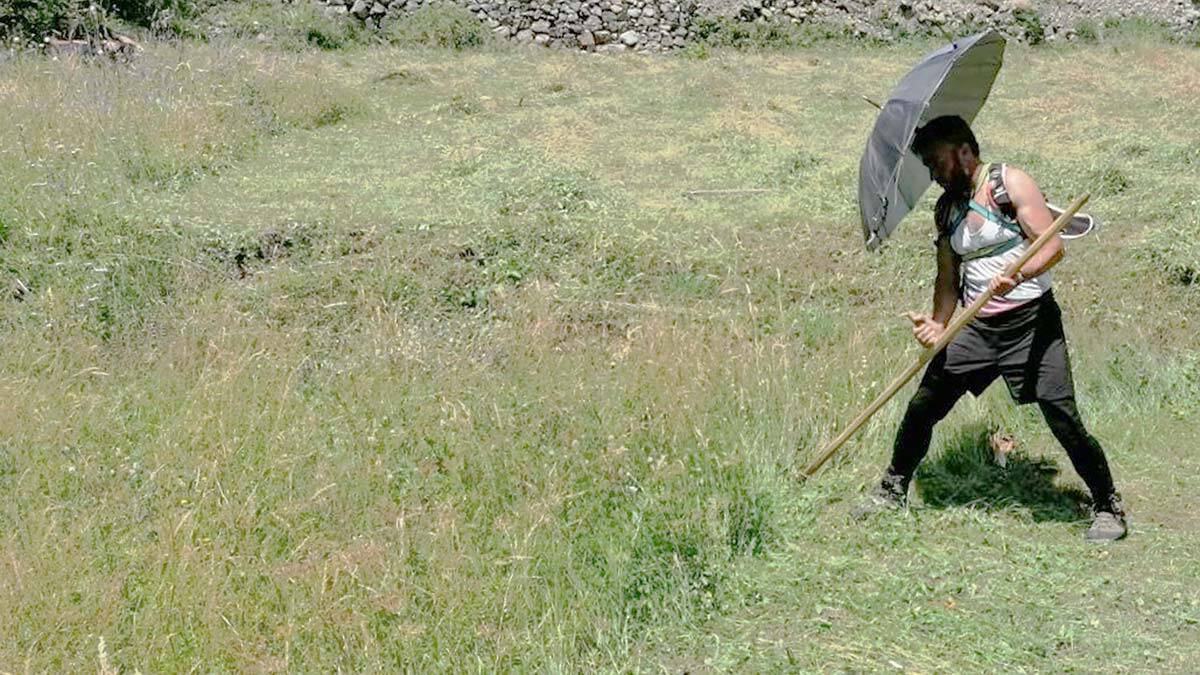 Şemsiyeyi omuzlarına bağlayarak gölgelik yaptı