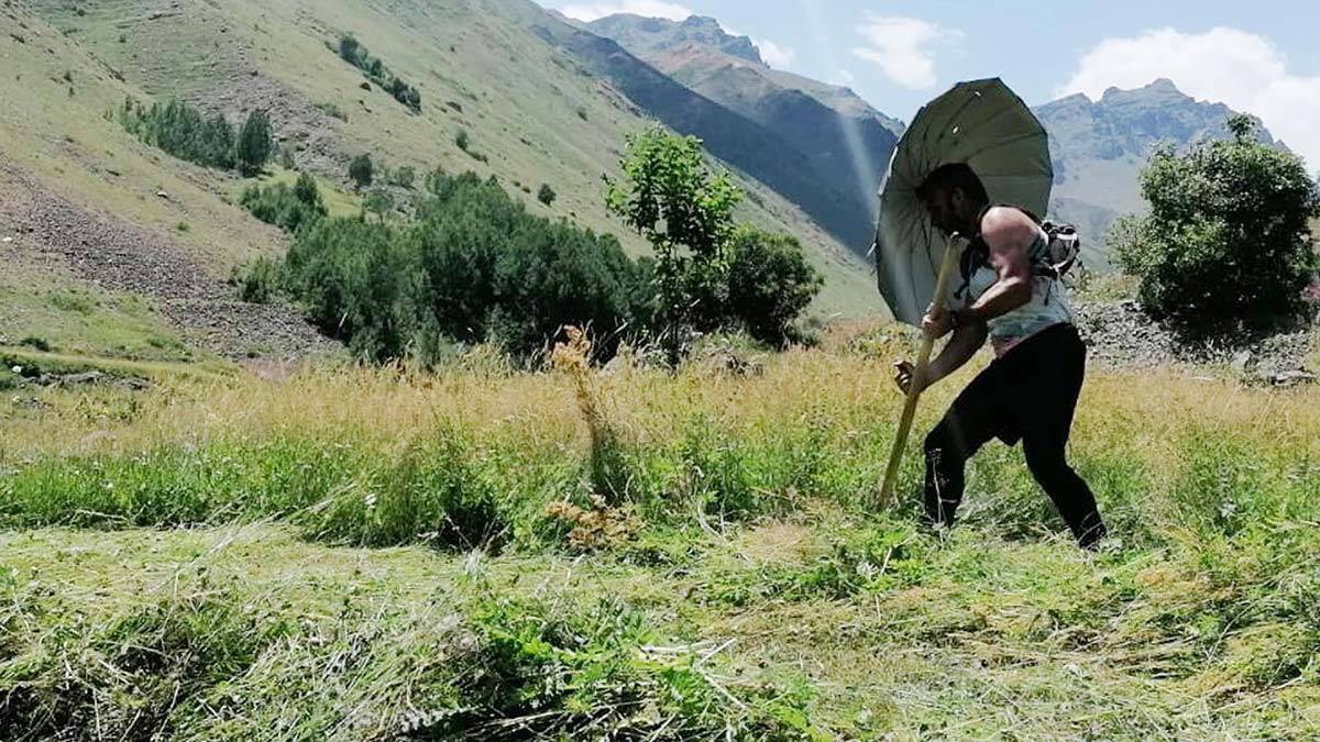 Şemsiyeyi omuzlarına bağlayarak gölgelik yaptı