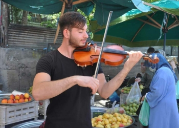 Keman eşliğinde sebze satıyor