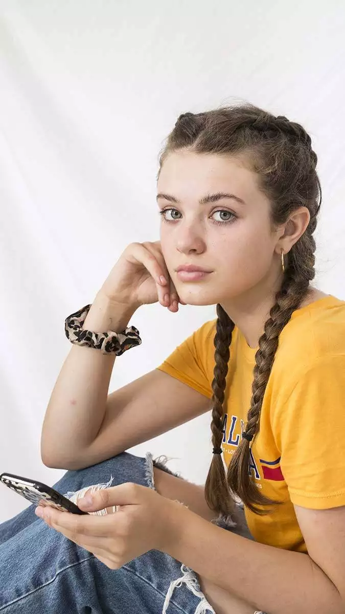 Beautiful young teenager yellow shirt ripped jeans with braided hair texting phone - yazarlar - haberton