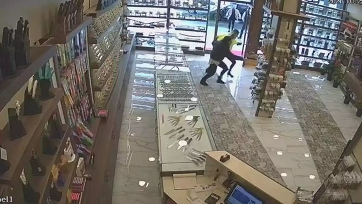 Görüntülerde, saldırganın mağazaya gelerek tabanca ile ateş ettiği görülüyor