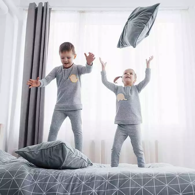 Happy kids playing white bedroom little boy girl brother sister play bed wearing pajamas nightwear bedding baby toddler family home - yazarlar - haberton