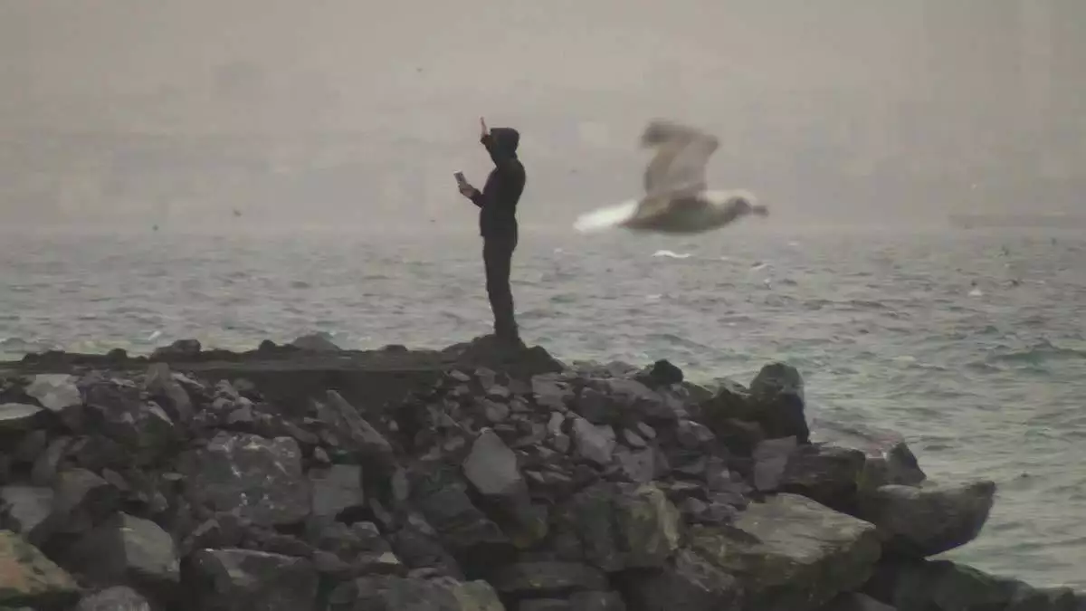 Sahilde yürüyüş yapan bazı vatandaşlar, kuvvetli rüzgara rağmen o anları cep telefonlarıyla kaydetti