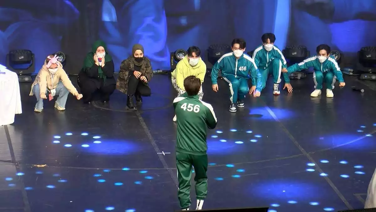 Koreli grup, sahnede squid game dizisindeki yarışmacıların kıyafetlerini giydi