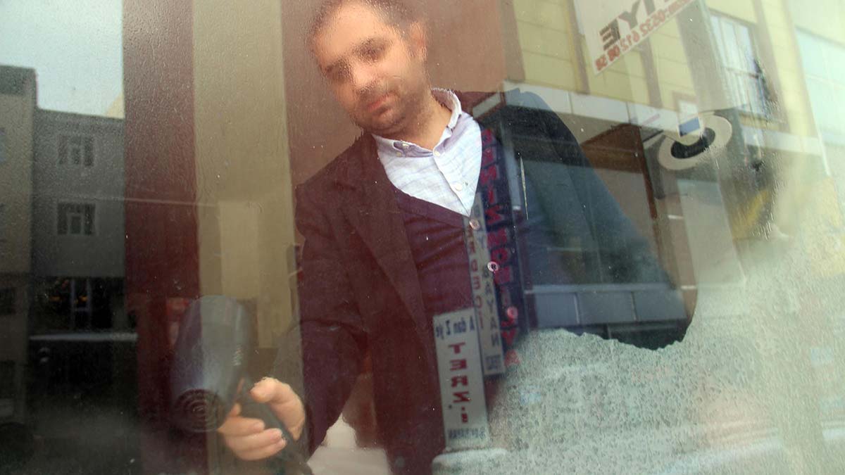 İş yerlerinin camları buz tutan esnaf, saç kurutma manikasıyla camların buzunu eritmeye çalıştı