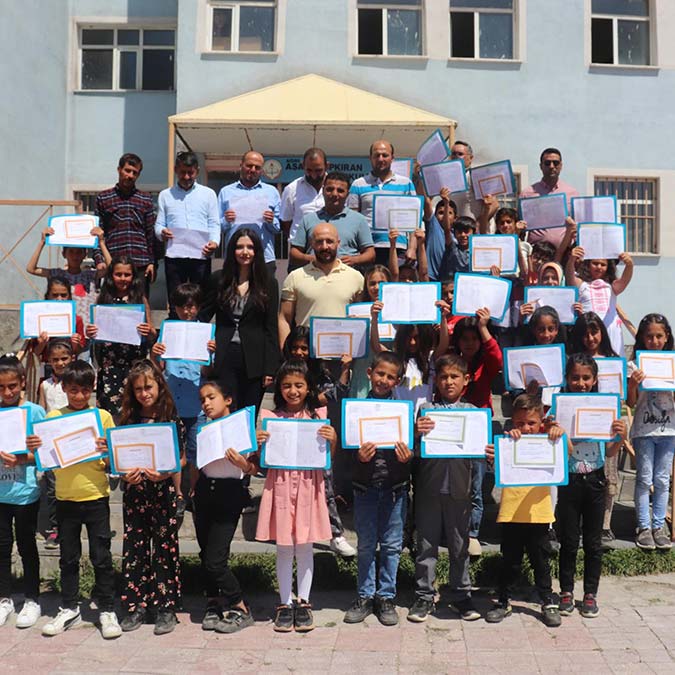 Ağrı'nın Aşağı Küpkıran Mahallesi'ndeki ilkokulda 2021-2022 eğitim öğretim sezonunun ikinci yarısından itibaren okul, öğretmen, öğrenci veli ilişkisini geliştirmek amaçlı projede derslere katılan babalar çocuklarıyla karne aldı.