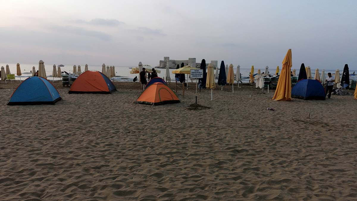Mersin'in önemli turizm noktalarından kızkalesi'nde otellerde boş yer kalmayınca turistler çadır kurup, konakladı.