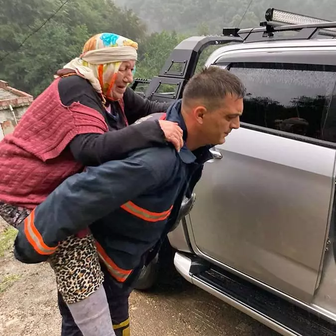 Yürümekte zorluk çeken fatma duymaz'ı sırtına alan itfaiye eri, metrelerce kadını sırtında taşıyarak güvenli bölgeye ulaştırdı.