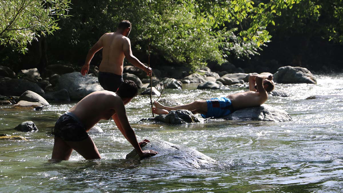 Hakkari'nin Yüksekova ilçesinde termometreler 40 dereceyi gösterince sıcaktan bunalanlar, kar suları ile beslenen Avaşin Deresi'nde serinledi.