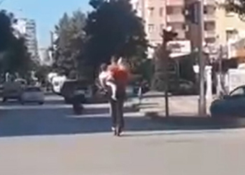 Kucağında bebek bulunan kadınla skuter yolculuğu