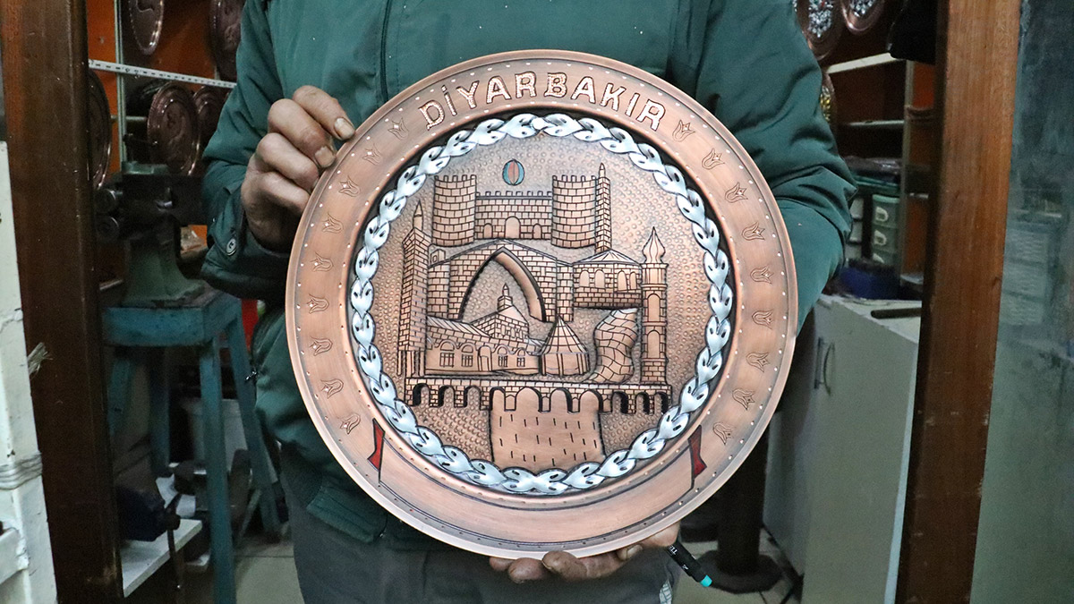 Bakır işlemeciliği ustası sembolleri levhaya işliyor