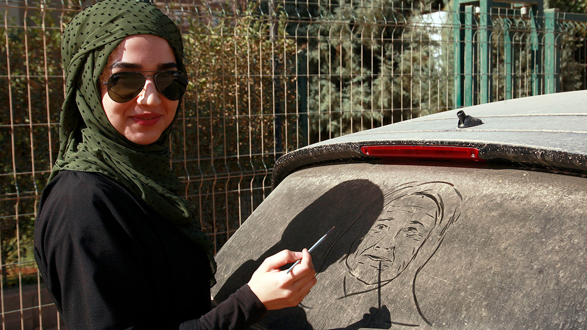 Tozlu araç camlarını tuval gibi kullanıyor