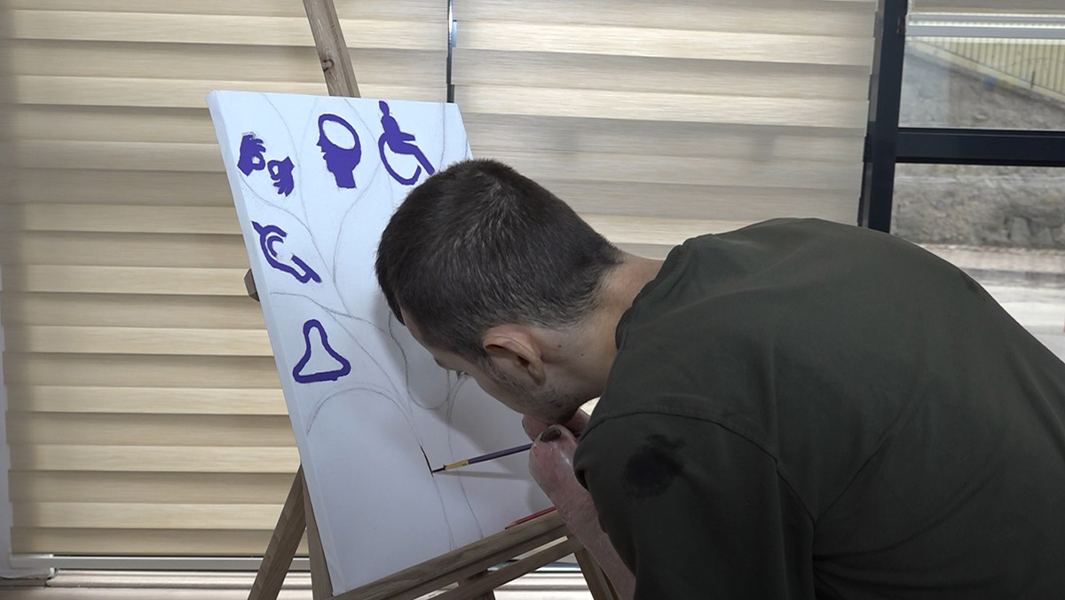 Bedensel engelli Ömer Pala kollarıyla resim yapıyor