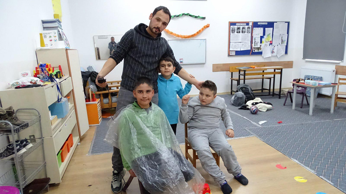 Özel gereksinimli öğrencilerini sınıfta tıraş ediyor