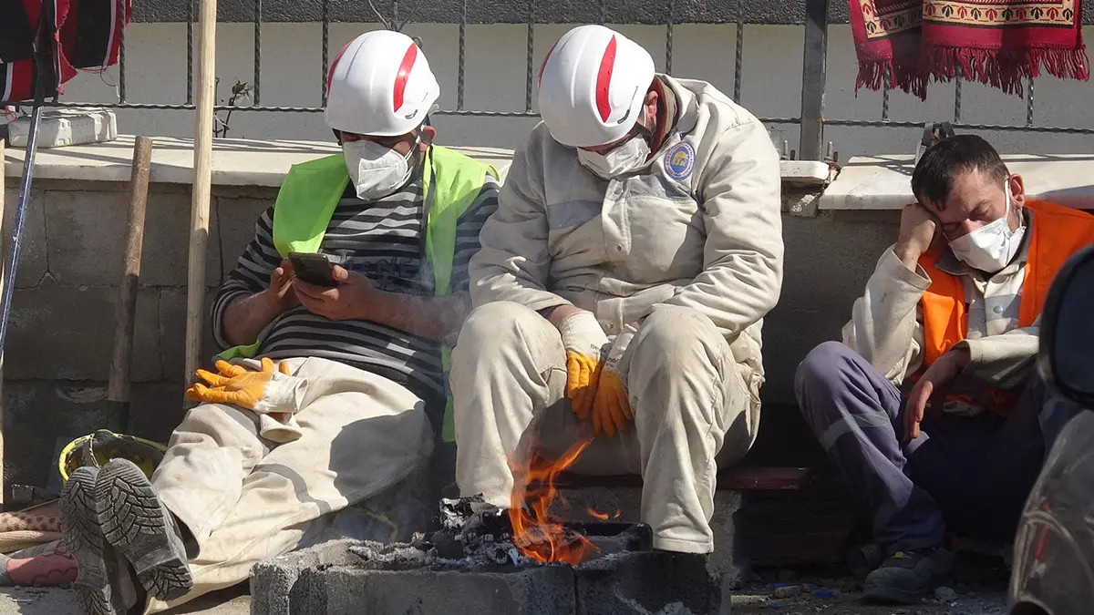 Yorgun düşen madenciler ateş başında dinleniyor
