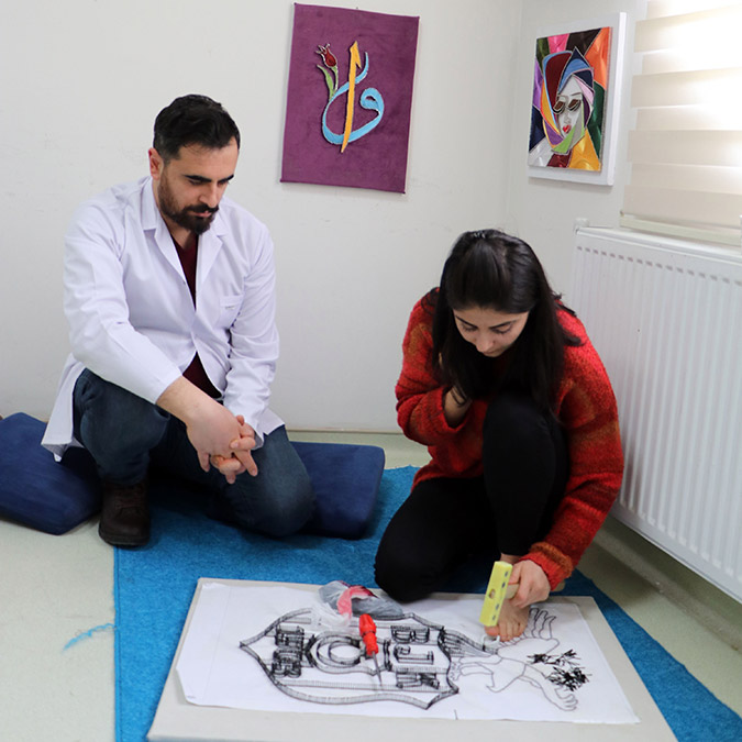 Tahta plakaya çivi çakarak filografi tablolar yapıyor