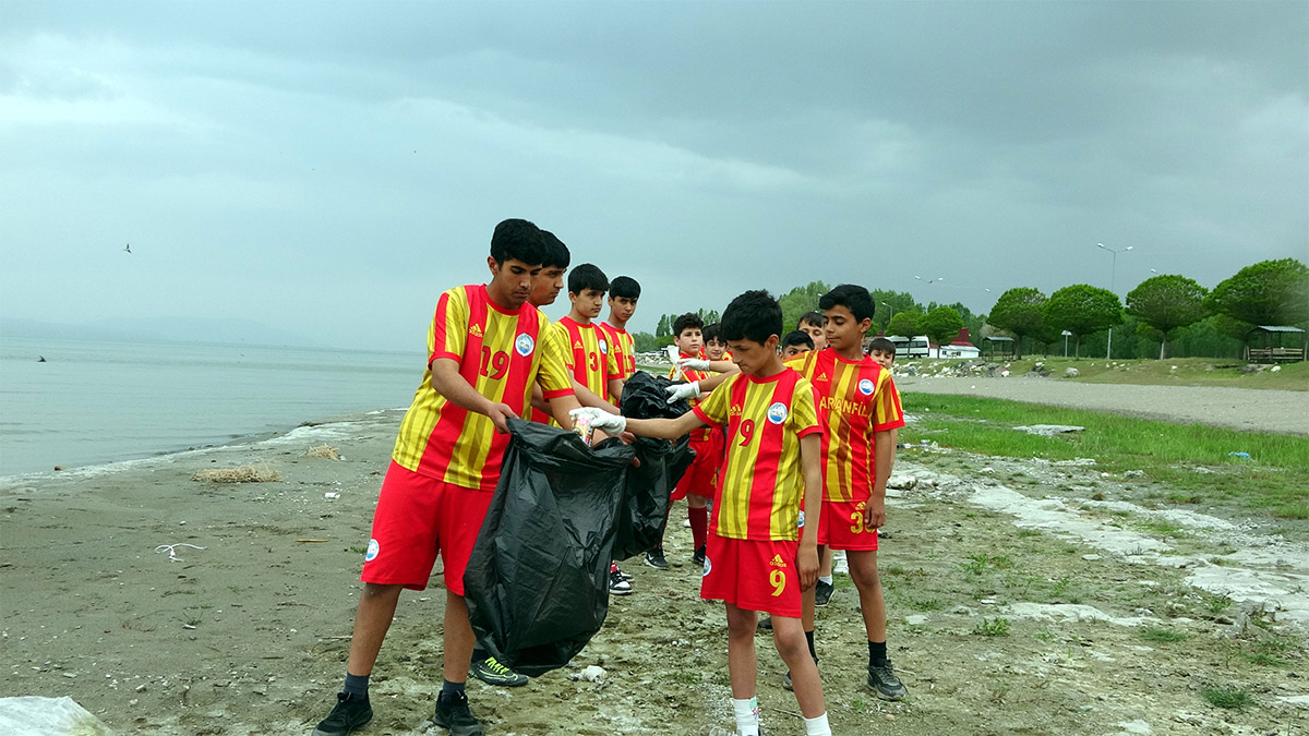 Van'ın Erciş ilçesindeki Erdiş Spor Futbol Okulu sporcuları, son yıllarda bölgedeki kuraklığa bağlı olarak Van Gölü'nde yaşanan çekilmelere dikkat çekmek amacıyla, göl kıyısında çöp toplayıp antrenman yaptı.
