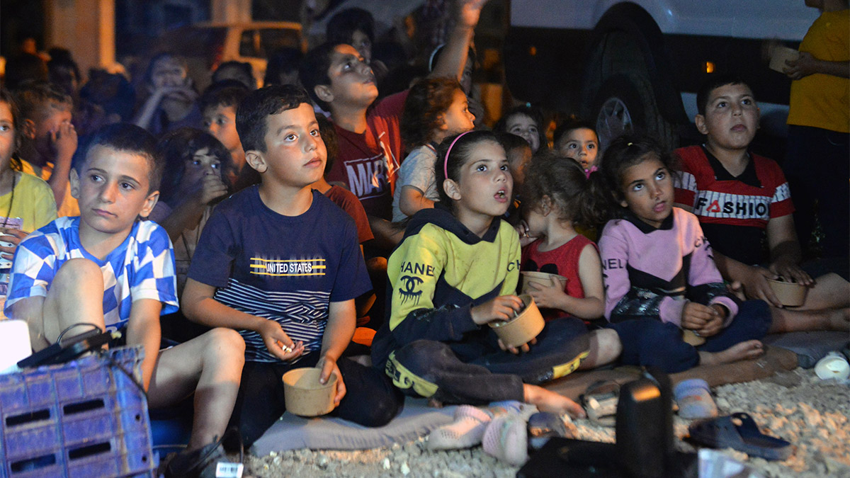 Hatay’daki çadır kentte kalan depremzede çocuklar, gönüllülerin kurduğu açık hava sinemasında, patlamış mısır eşliğinde ‘Aslan Kral’ animasyon filmini izledi.