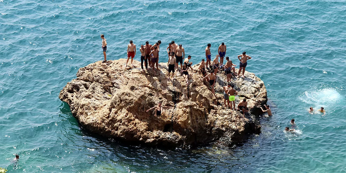 Antalya'da sıcak hava ve yüksek nem nedeniyle sahillerde yoğunluk oluştu. Tatilciler denize girip, serinlerken, nem bulutları nedeniyle beydağları görünmez oldu.