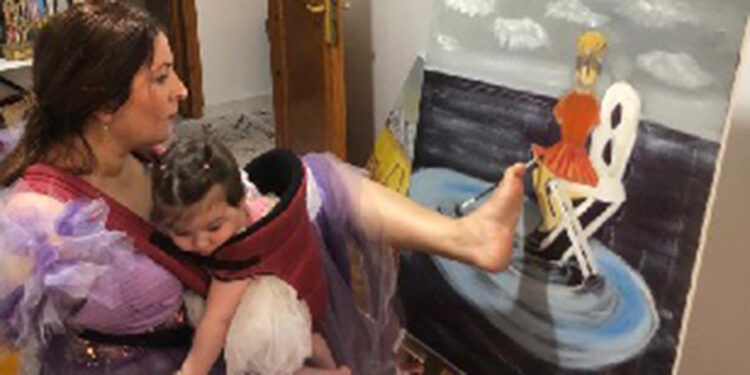 İki kolu da olmayan Ayşe, sol ayak parmağıyla resim yapıyor