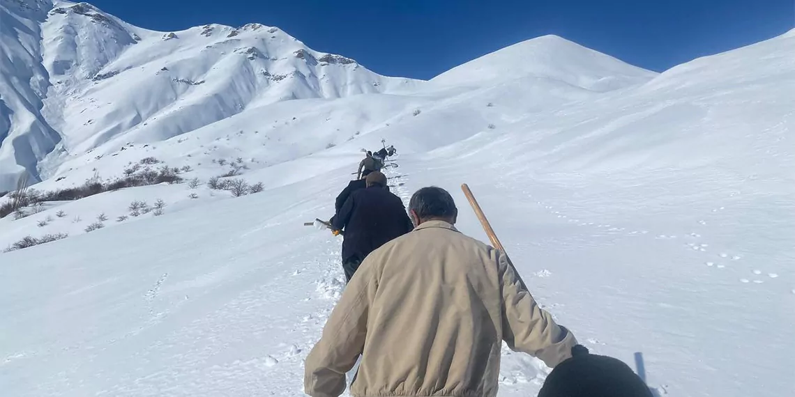 Küreklerle karlı bölgeyi aşıp, mahalleye su getirdiler