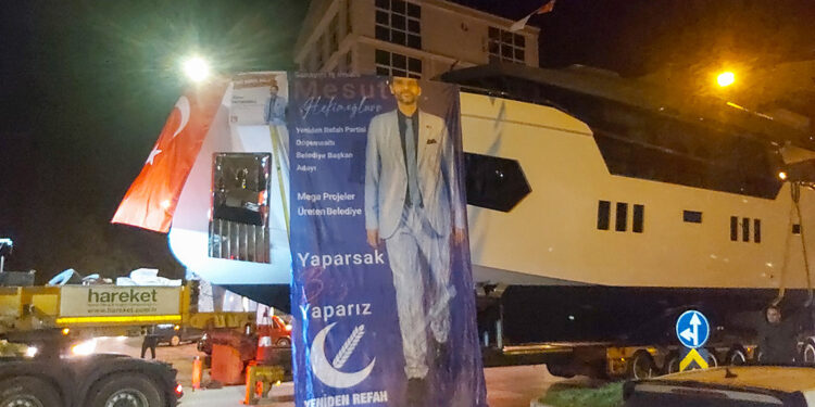 Kamyona yüklenen lüks yatla seçim konvoyu