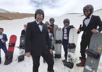 Takım elbise, kravat ve papyonla snowboard