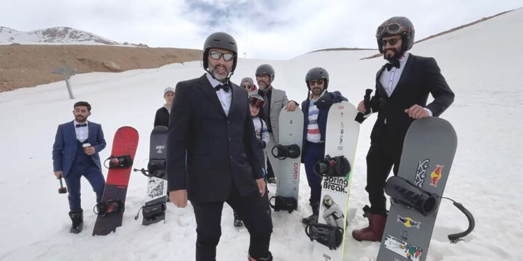 Takım elbise, kravat ve papyonla snowboard