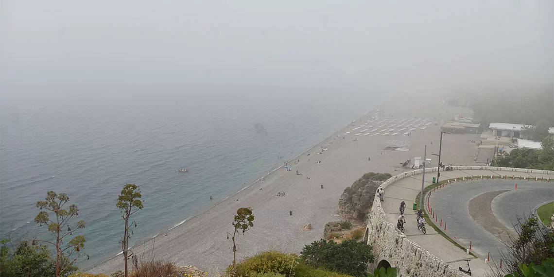 Antalya'da yüksek nem ve toz taşınımı nedeniyle sis oluştu, görüş mesafesi düştü. Yüksek katlı binalar, sisle kaplandı, falezlerden deniz görülemedi.