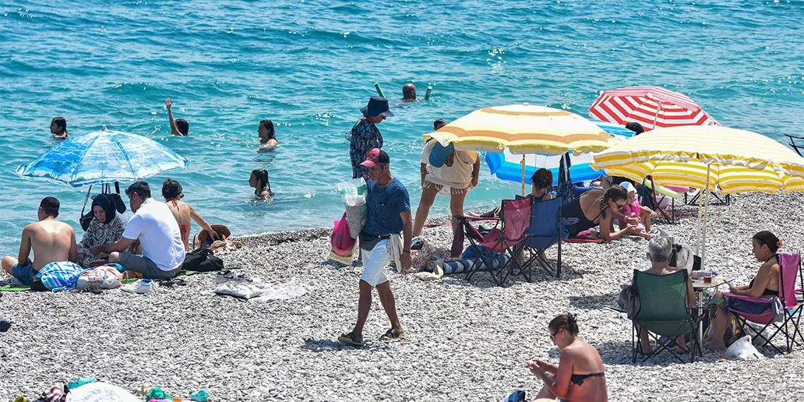 Antalya'da plajda güneşlenenler arasında dolaşarak tepside midye dolma, simit veya çekirdek, kovada mısır, poşette pamuk şeker satan seyyar satıcılar halk sağlığı açısından risk oluşturuyor.