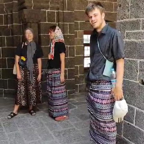 Ulu Camii'yi ziyaret eden erkek turistler, kadınlar için ayrılan etekleri giydi