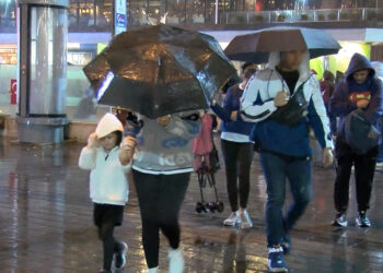 Taksim Meydanı'nda yağmura yakalananlar otobüs durağına sığındı