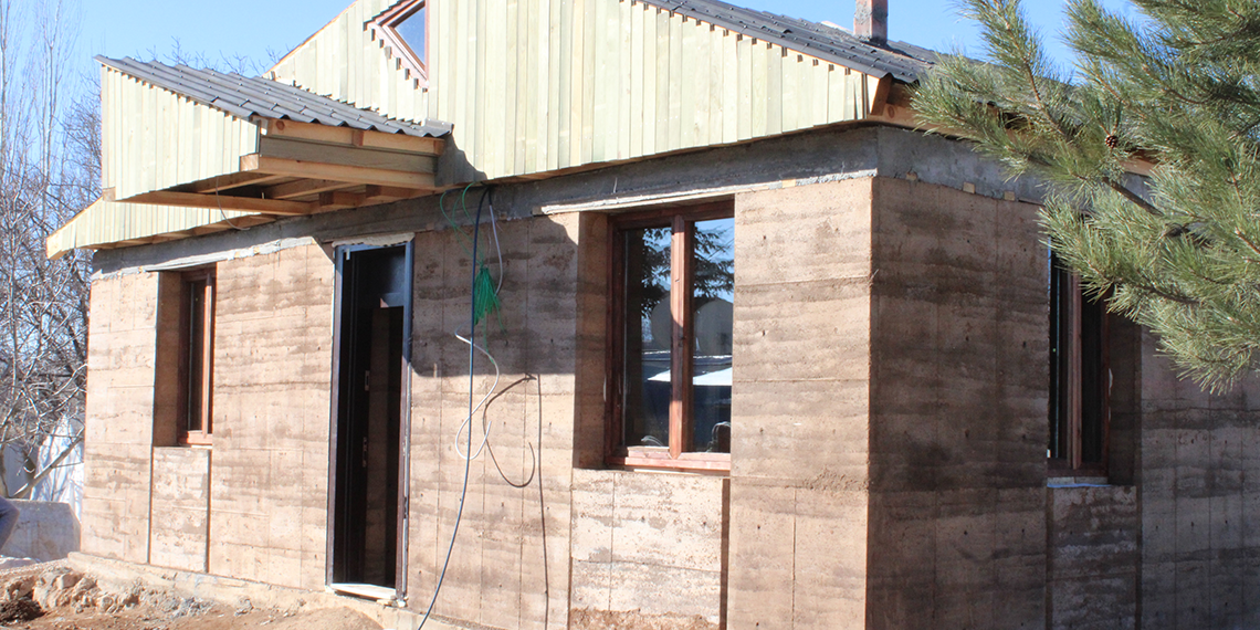 Öğrencilerinden depremzede kadına sıkıştırılmış toprak tekniğiyle ev