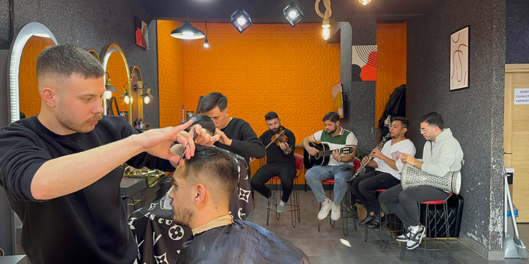 Müzik eşliğinde müşterilerini tıraş ediyor