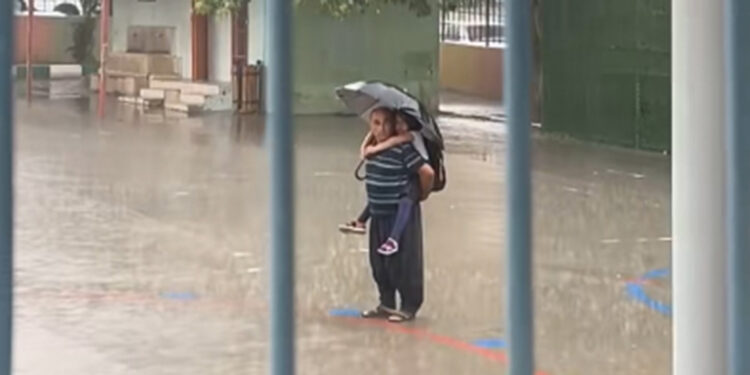 Sağanak altında torunu ile İstiklal Marşı'nı dinlediler
