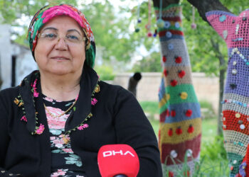 Bahçesindeki ağaçları ördüğü örgüler ile süsledi