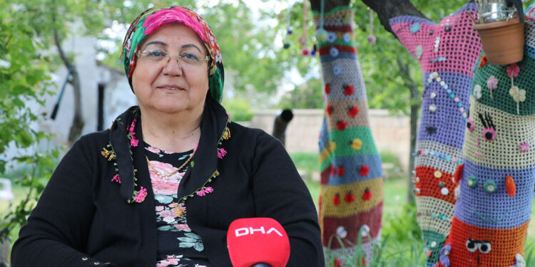 Bahçesindeki ağaçları ördüğü örgüler ile süsledi