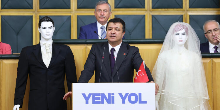 Mahmut Arıkan kürsüye gelin ve damat mankeniyle çıktı