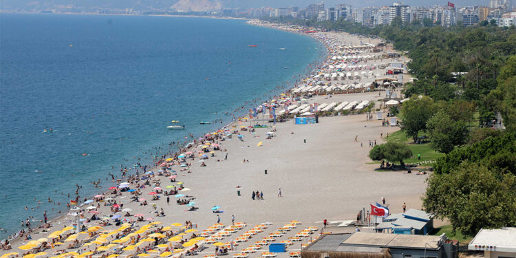 Sıcak hava bunalttı; tatilciler soluğu Konyaaltı Sahili'nde aldı