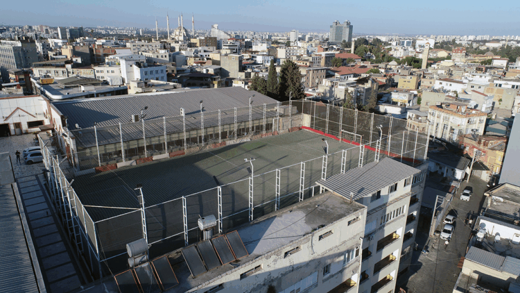 Adana'nın tarihi dokusunun arasındaki 5 katlı binanın çatısında futbol 