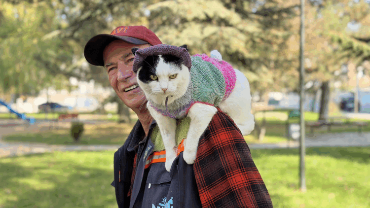 Birlikte 65 şehir gezdiği kedisini omzunda taşıyor