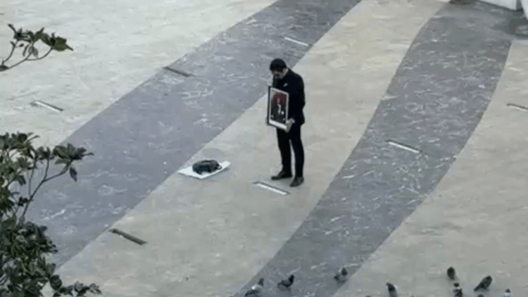 Elinde Atatürk tablosu ile saygı duruşunda bulundu