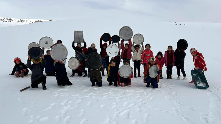 Evlerinden getirdikleri tepsilerle köy merasında kayak yaptılar